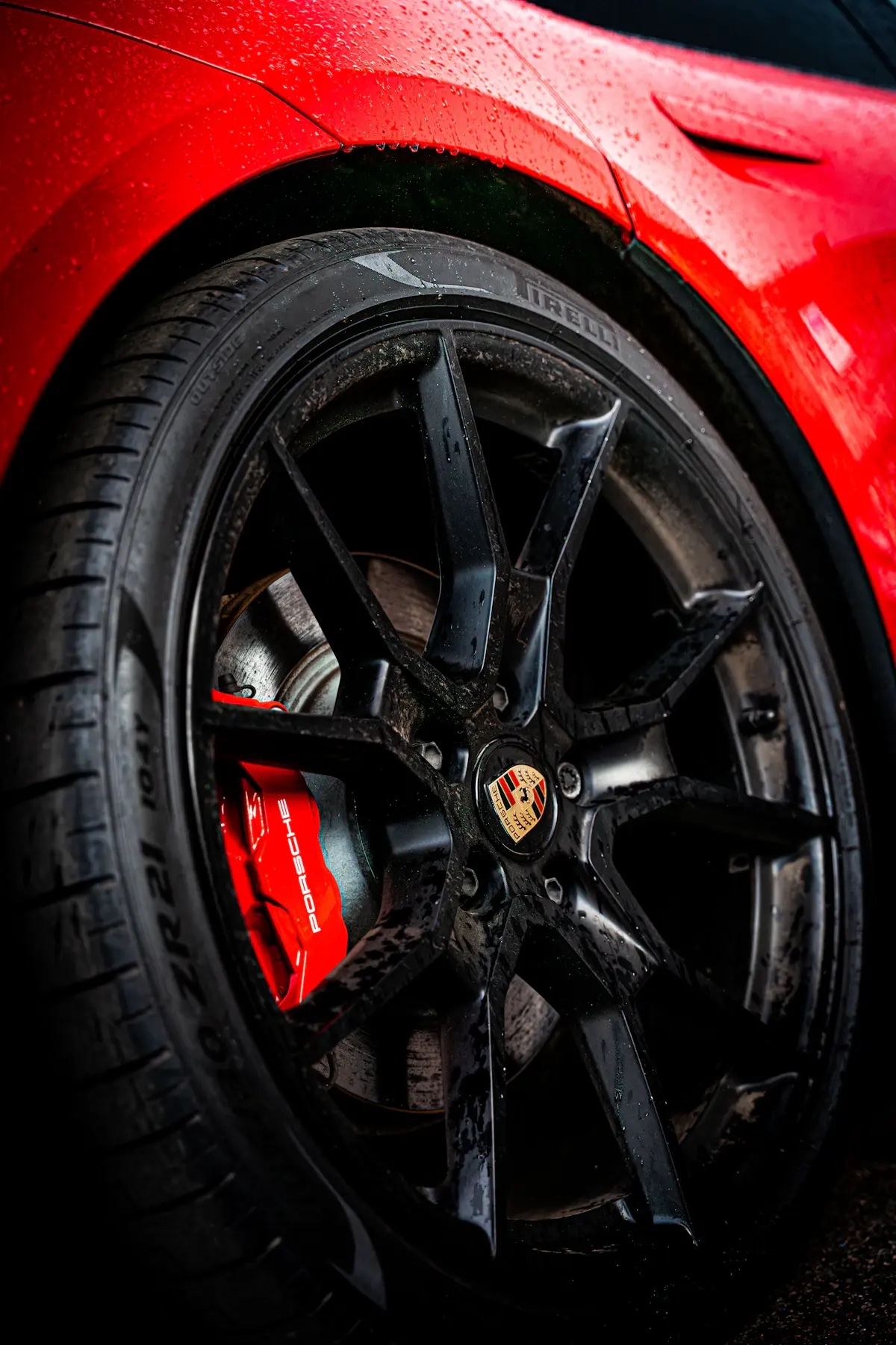 Gros plan sur une jante en alliage noire montee sur voiture rouge