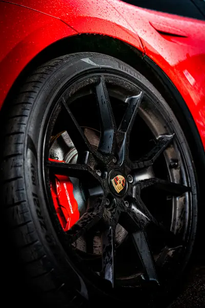 Gros plan sur une jante en alliage noire montee sur voiture rouge